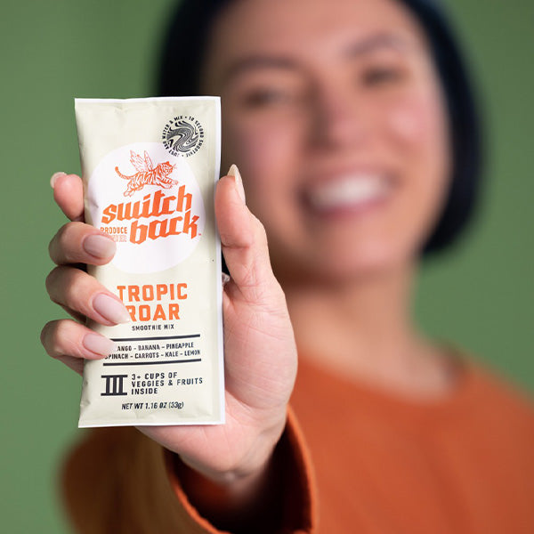 Woman Holding Packet of Tropic Roar Smoothie Mix